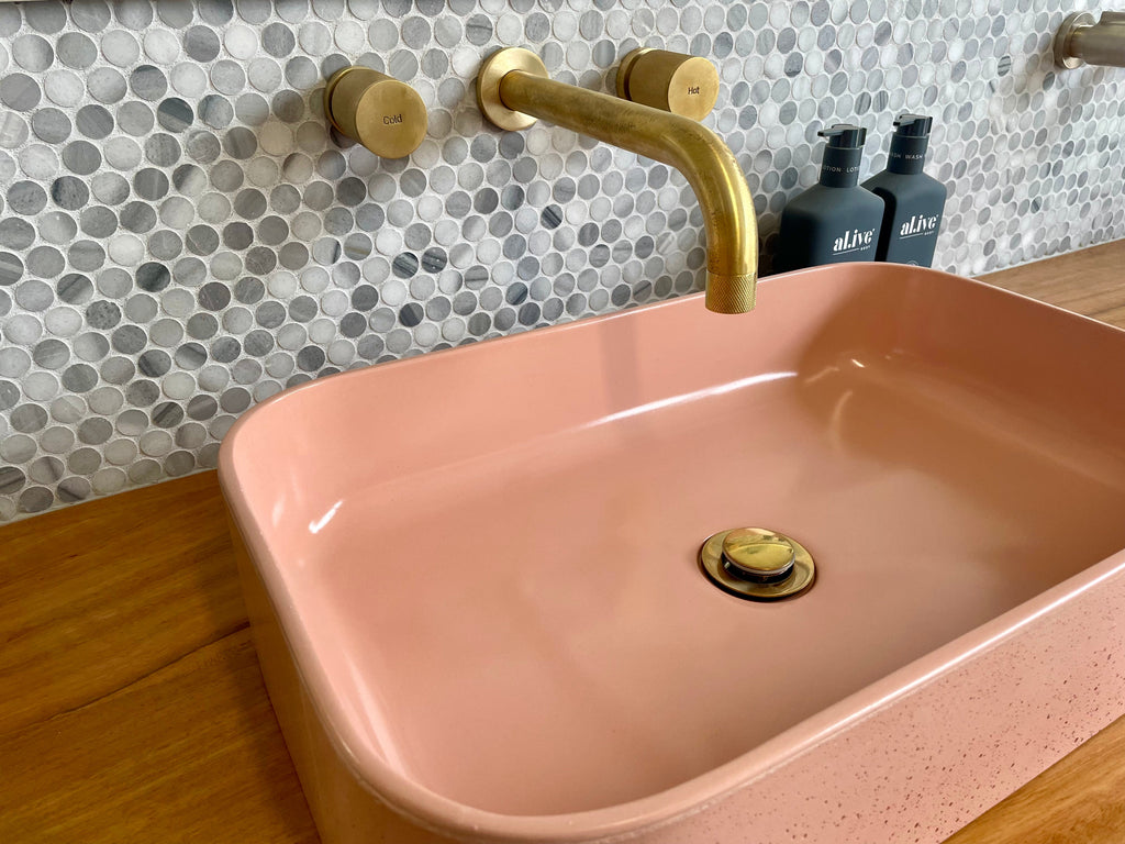 IDK Par Taps wall basin set in natural brass with an Illy Main concrete basin by DLH Designs in Peachy pink